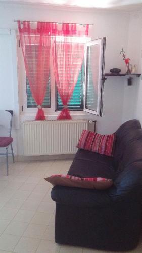 a living room with a couch and two windows at Apartments Anita in Srima