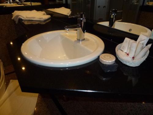 a sink in a bathroom with a black counter top at Kasteel van Nieuwland in Aarschot
