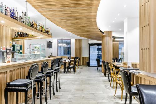 a restaurant with black chairs and a bar at Hotel Reina Cristina in Teruel