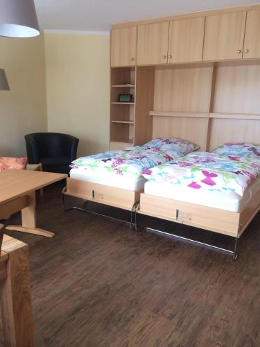 1 dormitorio con cama, escritorio y mesa en Ferienwohnung-Putz en Altreichenau