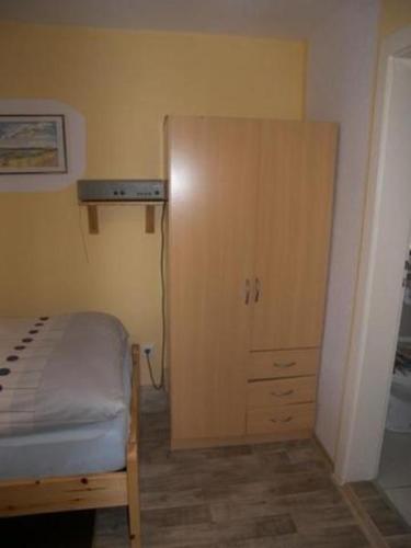 a bedroom with a bed and a wooden cabinet at Ferienunterkuenfte Schulz in Ahlbeck
