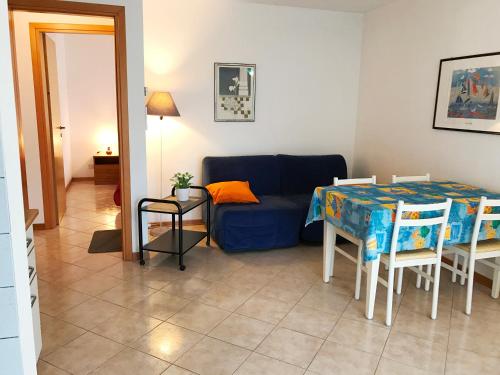 ein Wohnzimmer mit einem blauen Sofa und einem Tisch in der Unterkunft Villa Daniela Apartment in Grado