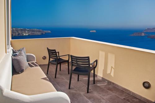 a balcony with chairs and a couch and a view of the ocean at Santa Rinoula Suites Sea Sunset views Adults only in Megalokhori