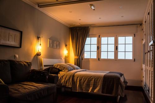 um quarto com uma cama, um sofá e uma janela em Picaflor em Las Palmas de Gran Canaria