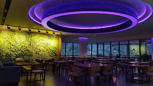 a restaurant with purple lighting and tables and chairs at Hotel Vidikovac in Zvornik