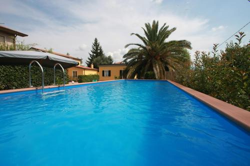 una grande piscina blu di fronte a una casa di La Via dei Cardi a Sarzana
