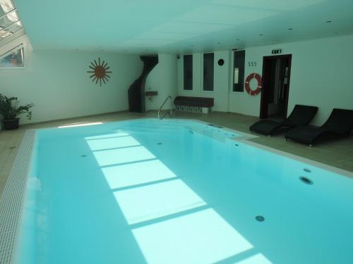 a large swimming pool with blue lights in a room at Hotel Restaurant Marienhof in Unterkirchbach