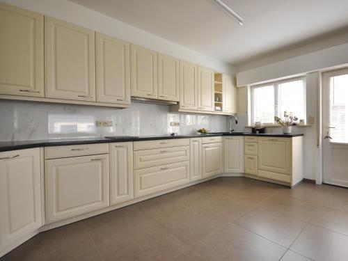 a kitchen with white cabinets and a tile floor at De Witte Parel in Oostduinkerke