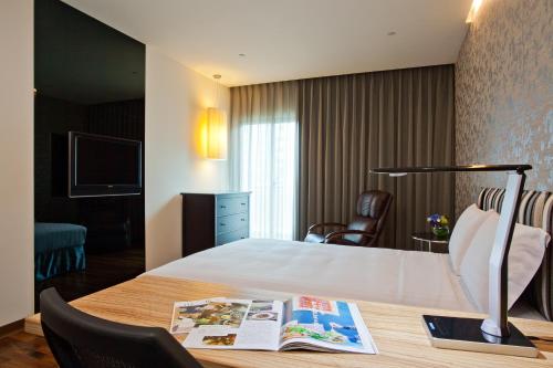 a hotel room with a bed and a book on a table at Howard Plaza Hotel Hsinchu in Hsinchu City