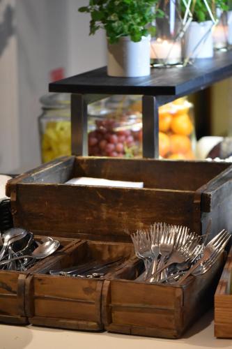 a wooden tray filled with spoons and forks at Home Hotel Victoria in Jönköping
