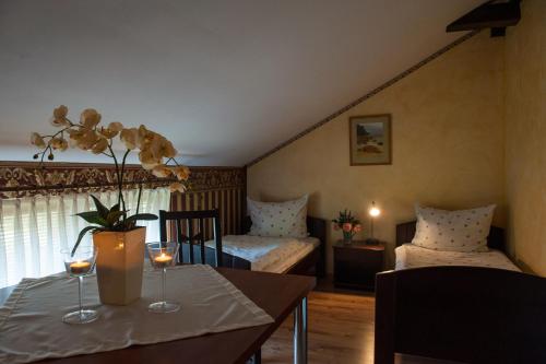 una habitación con 2 camas y una mesa con copas de vino en Villa Ambra, en Osowa