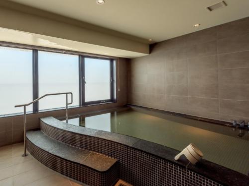 a swimming pool with a tub in a building at Sheraton Okinawa Sunmarina Resort in Onna
