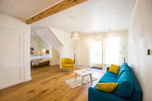 a living room with a blue couch and a bedroom at Haapsalu Old Town Apartments in Haapsalu