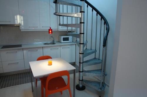 a spiral staircase in a kitchen with a table and chairs at Clemens in Málaga