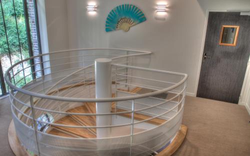 a spiral staircase in a room with a table at Hôtel de la Tabletterie in Méru
