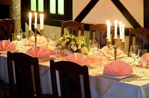 a dining table with candles and flowers on it at Hotel Victoria in Szczecin