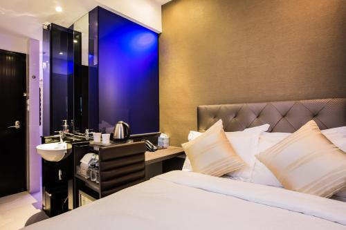 a hotel room with a bed and a sink at Arton Boutique Hotel in Singapore