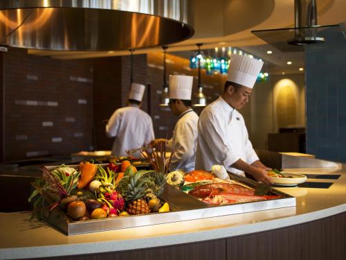 a group of chefs preparing food in a kitchen at Sheraton Okinawa Sunmarina Resort in Onna