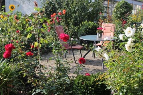 two chairs and a table in a garden with flowers at No. 73 - Idylle im Rebenmeer in Pleisweiler-Oberhofen