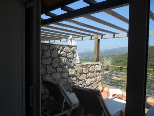 a room with a view of a stone wall and chairs at Allegroitalia Elba Golf in Portoferraio