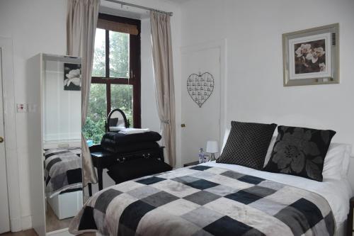 a bedroom with a bed and a chair and a window at Flat G/R 59 Erskine Street Aberdeen in Aberdeen