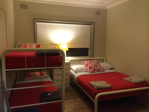 a small room with two bunk beds and a mirror at Guesthouse 83 in Cronulla