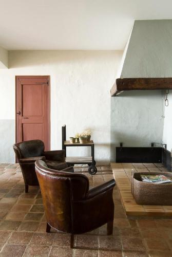 a living room with leather chairs and a table at Can Mora de Dalt in Sant Vicenç de Montalt