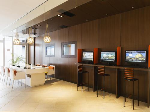 a restaurant with a table and chairs and televisions at Sheraton Okinawa Sunmarina Resort in Onna