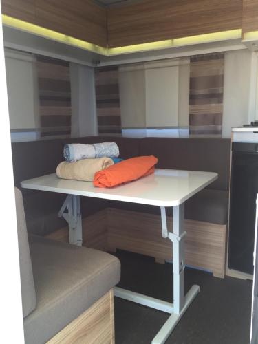 a white table with two pillows on it in a kitchen at Caravans through the nature in Mikhmoret