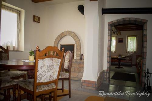 ein Esszimmer mit einem Tisch und einem Kamin in der Unterkunft Romantika Vendégház in Bordány