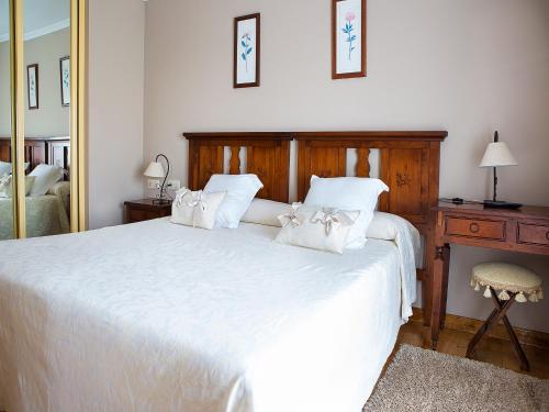 a bedroom with a large white bed with white pillows at Casa Maravilla in Faro de Peñas