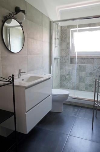 a bathroom with a sink and a toilet and a mirror at Lisbon Beach Apartments 3 in Costa da Caparica