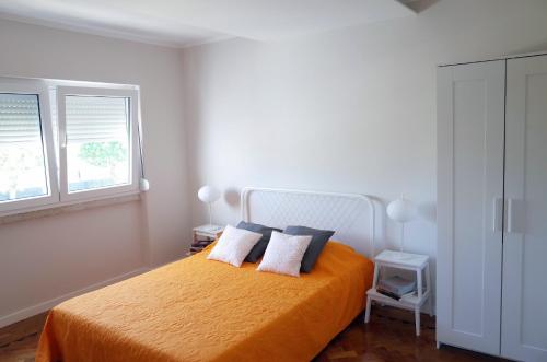 コスタ・ダ・カパリカにあるLisbon Beach Apartments 3のベッドルーム1室(枕2つ、窓付)