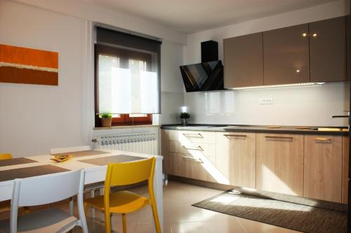 a kitchen with a table and yellow chairs at Apartment Magnolia in Mušalež