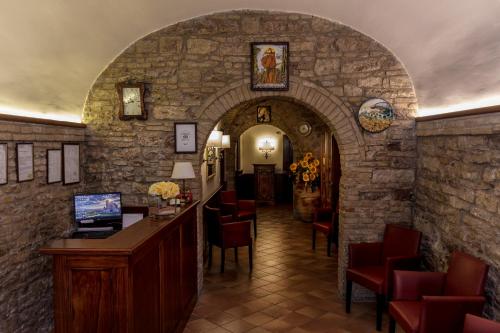 an archway in a building with a bar and chairs at Hotel Pax in Assisi