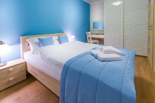 ダルウフコにあるApartament Turkusの青い壁のベッドルーム1室(大型ベッド1台付)