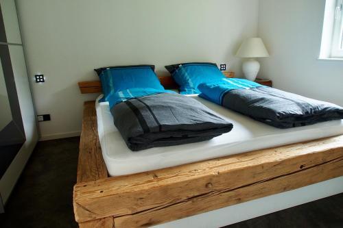 a bed with blue pillows on it in a room at Ferienwohnung Almflair Chalet in Thiersee