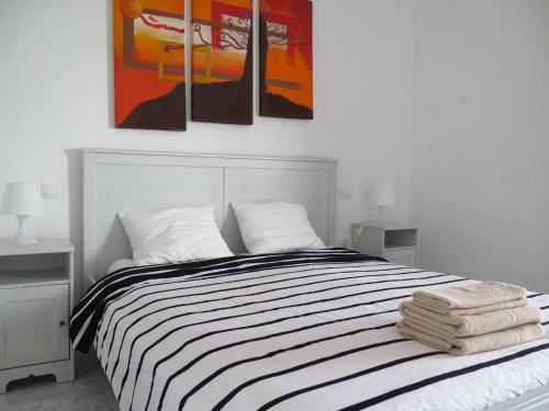 プラヤ・オンダにあるCasa Mi Lanzaroteのベッドルーム1室(壁に絵画3点が飾られたベッド1台付)