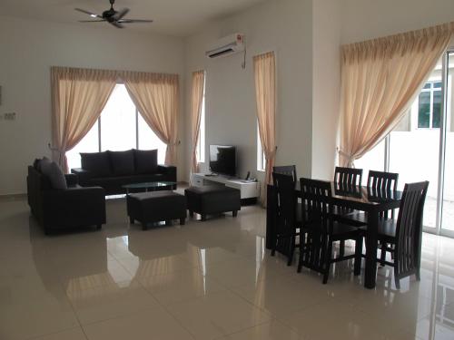 uma sala de estar com um sofá, uma mesa e cadeiras em Properties Homestay, Balik Pulau em Balik Pulau
