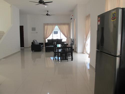 a kitchen and living room with a refrigerator and chairs at Properties Homestay, Balik Pulau in Balik Pulau