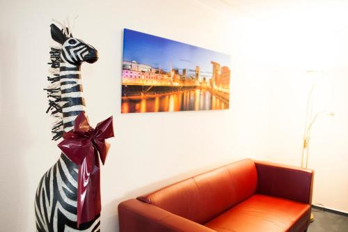 a zebra statue next to a couch in a room at Hotel Am Düsseldorfer Platz in Ratingen