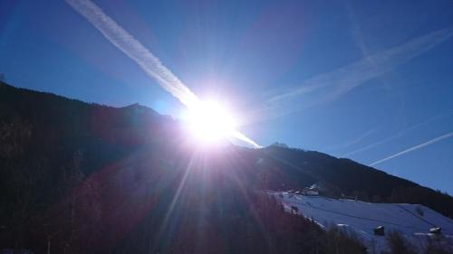 a sun is shining on top of a mountain at Haus Rosmarie in Neustift im Stubaital