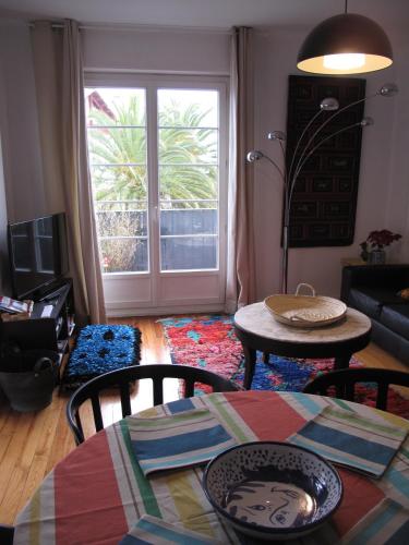 a living room with a table and chairs and a window at IBERIA 1 appartement T3 à 200 m de la plage avec parking privé in Hendaye