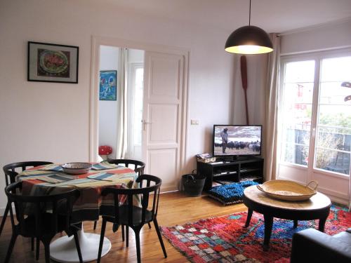 a living room with a table and chairs and a television at IBERIA 1 appartement T3 à 200 m de la plage avec parking privé in Hendaye