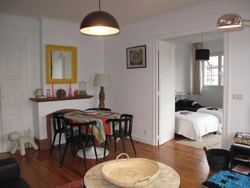 アンダイエにあるIBERIA 1 appartement T3 à 200 m de la plage avec parking privéのリビングルーム(テーブル、椅子付)、ベッドルーム1室が備わります。