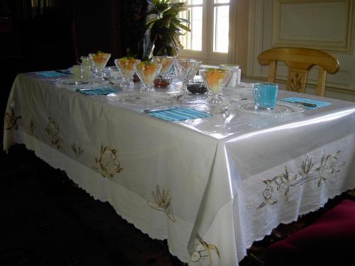 una mesa con un mantel blanco con gafas. en L'Isle de Bourbon, en Le Gué-de-Velluire