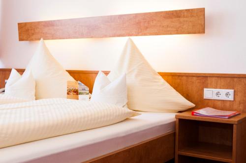 a bedroom with a bed with white pillows on it at Hotel Am Düsseldorfer Platz in Ratingen