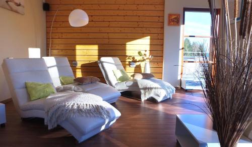 twee witte stoelen in een kamer met houten wanden bij VVF Les Fontaines des Vosges in Saales