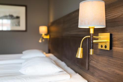 a hotel room with two beds and a lamp at Home Hotel Uman in Umeå