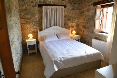 a bedroom with a white bed and two tables with lamps at Spiti tis Irinis in Pedoulas